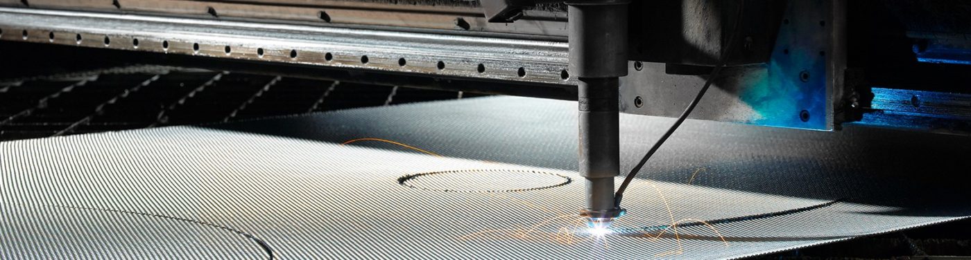 A machine cutting metal with a circular hole in the middle.