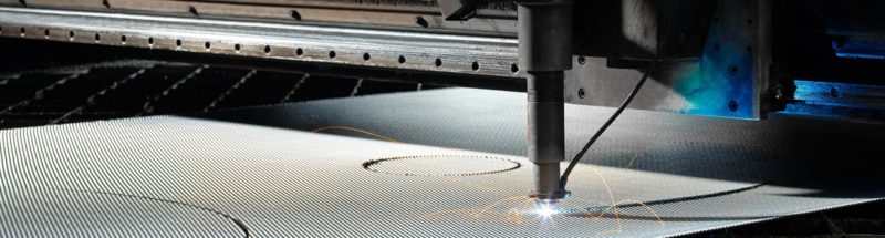 A machine cutting metal with a circular hole in the middle.
