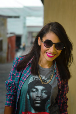 A woman wearing sunglasses and smiling for the camera.